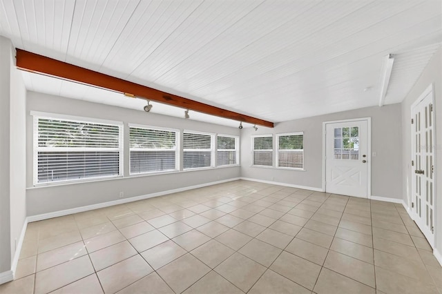 unfurnished sunroom featuring vaulted ceiling with beams