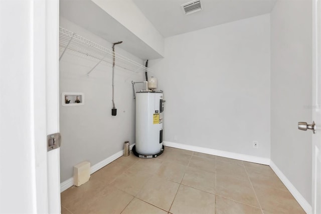 laundry area with washer hookup, light tile patterned flooring, and electric water heater