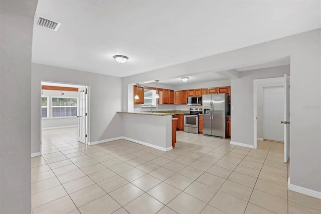 kitchen featuring light stone countertops, kitchen peninsula, stainless steel appliances, and light tile patterned floors