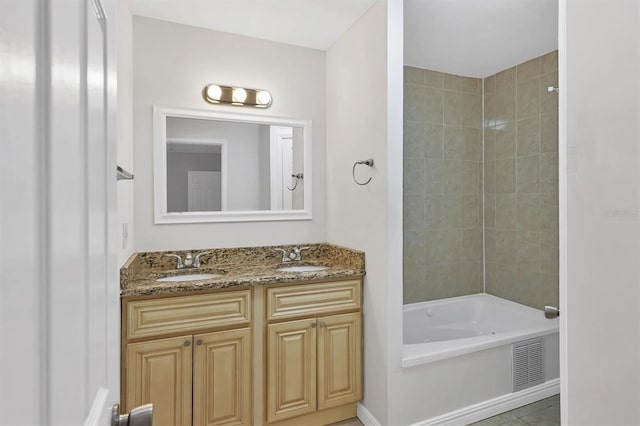 bathroom featuring tile patterned floors, vanity, and tiled shower / bath