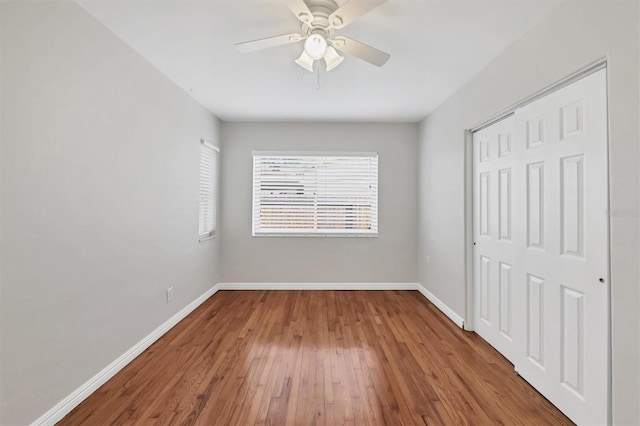 unfurnished bedroom featuring hardwood / wood-style flooring, ceiling fan, and a closet