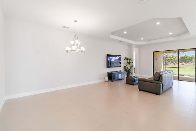 living room with a raised ceiling and a notable chandelier