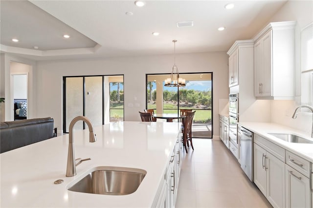 kitchen featuring white cabinets, pendant lighting, stainless steel appliances, and sink