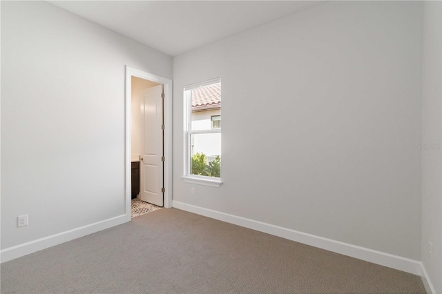 unfurnished room featuring light carpet