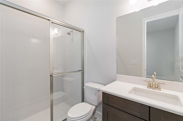 bathroom with toilet, vanity, and walk in shower