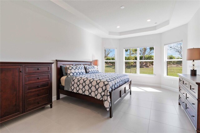 tiled bedroom with a raised ceiling