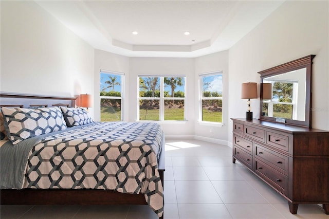 bedroom with light tile patterned flooring and a tray ceiling