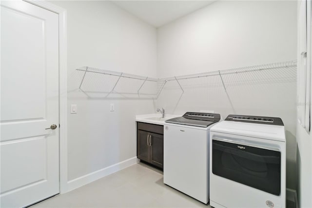 clothes washing area featuring cabinets, separate washer and dryer, sink, and light tile patterned floors