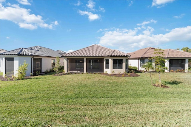 back of property featuring a lawn and a sunroom