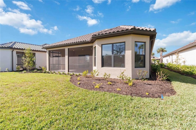 back of property featuring a sunroom and a yard