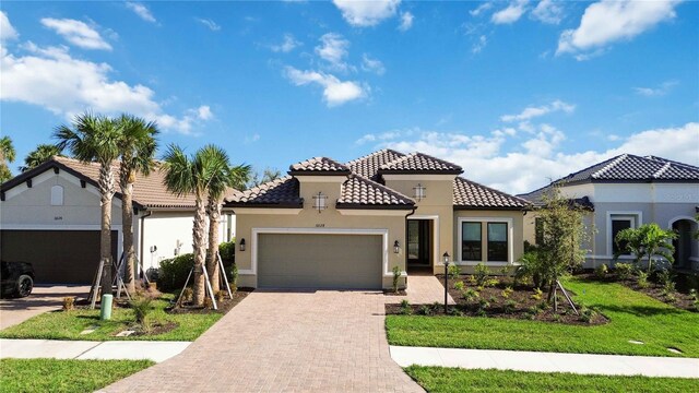 mediterranean / spanish-style home with a front yard and a garage