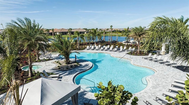 view of swimming pool with a water view and a patio area