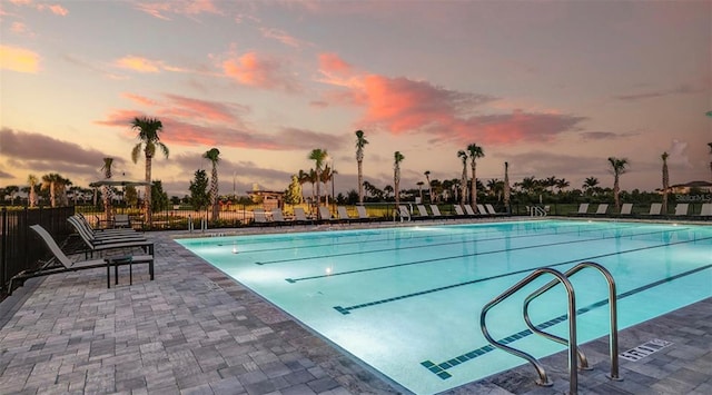 pool at dusk featuring a patio area