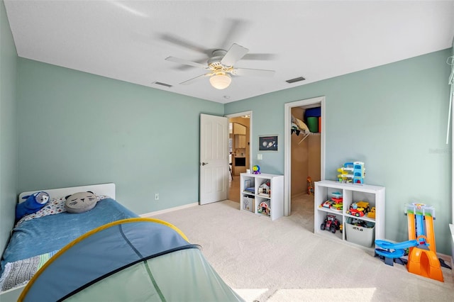 carpeted bedroom with ceiling fan, a spacious closet, and a closet