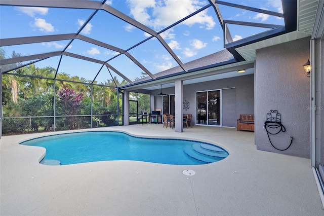 view of pool featuring glass enclosure and a patio