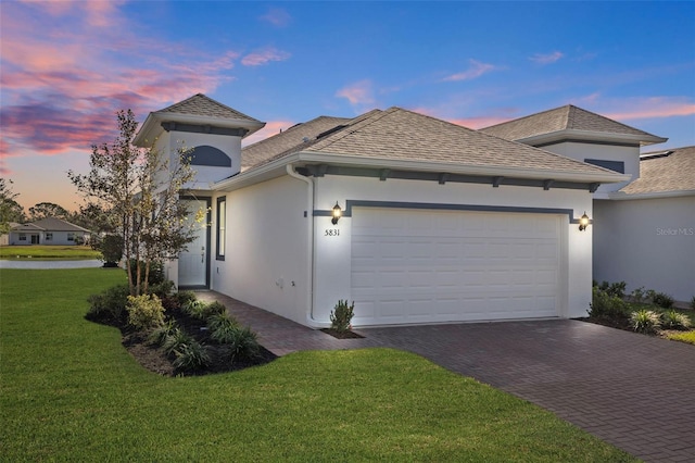 view of front of property featuring a yard and a garage