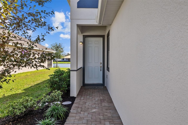 view of exterior entry featuring a yard