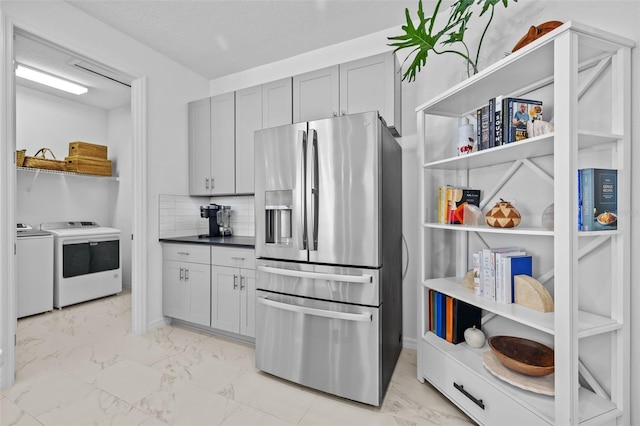 kitchen featuring backsplash, separate washer and dryer, stainless steel fridge with ice dispenser, and gray cabinets