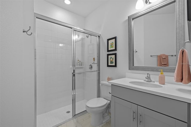 bathroom with vanity, toilet, and a shower with shower door