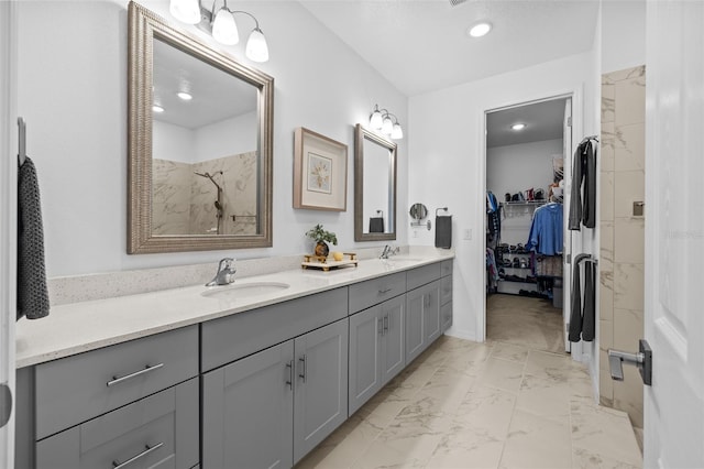 bathroom featuring tiled shower and vanity