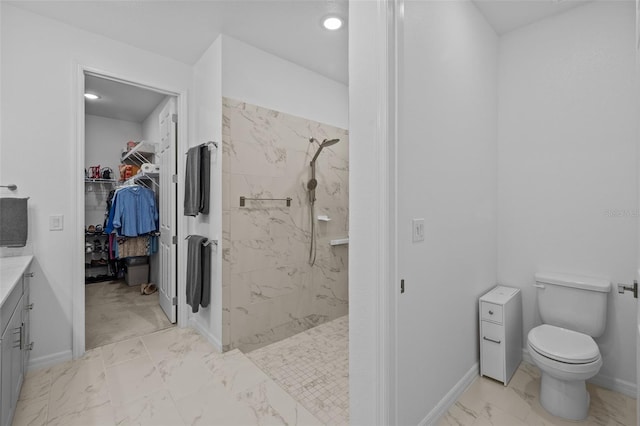 bathroom with vanity, toilet, and a tile shower