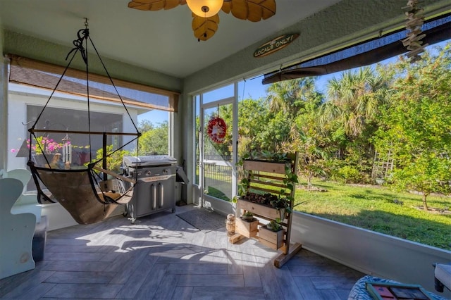 unfurnished sunroom with ceiling fan