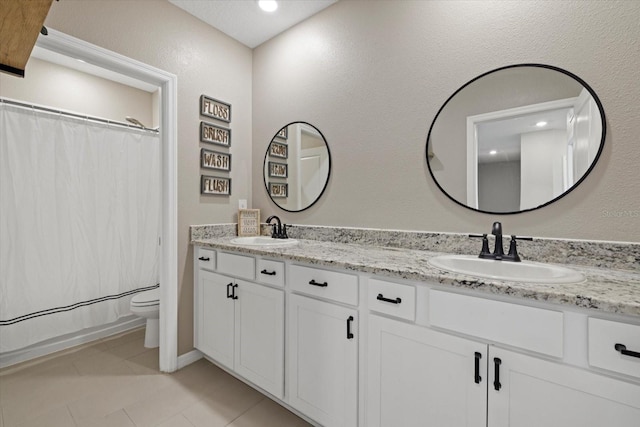 bathroom featuring tile patterned flooring, vanity, and toilet