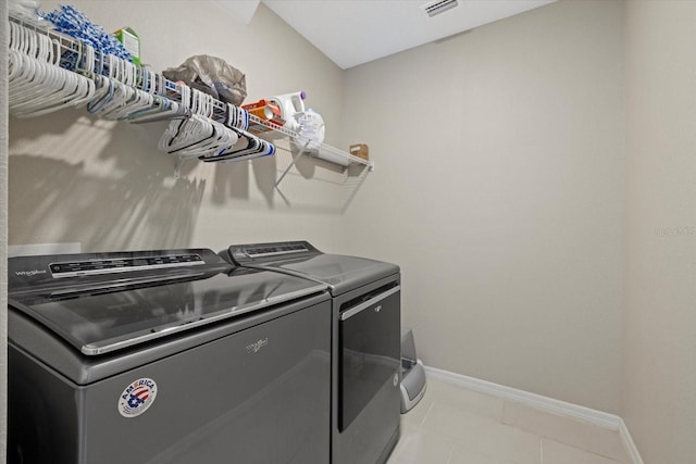 laundry area featuring washer and dryer and light tile patterned floors