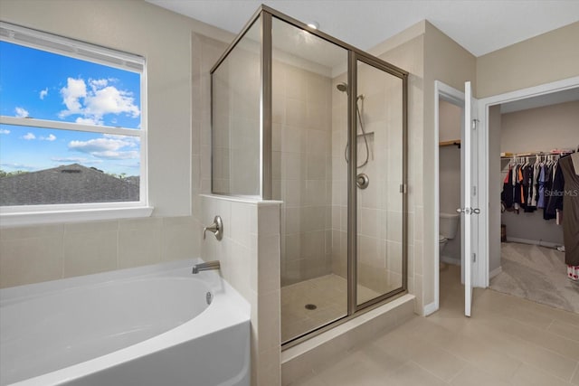 bathroom featuring shower with separate bathtub and toilet