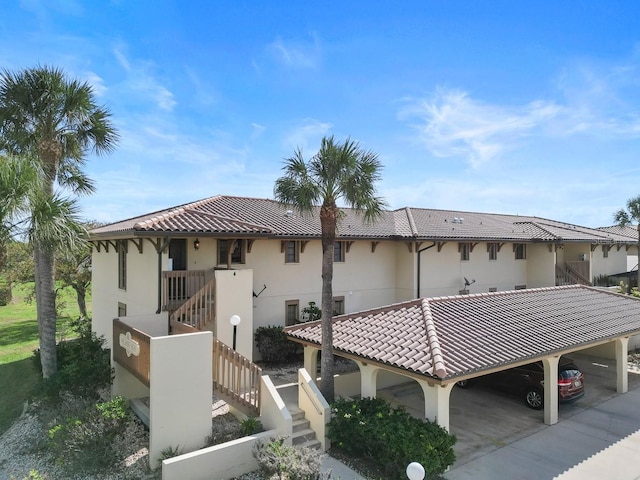 208 Lewis Cir Unit 4A, Punta Gorda, FL 33950 - rear view of house with a tiled roof, stairs, and stucco siding