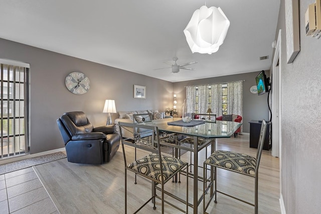 dining room with ceiling fan and light hardwood / wood-style flooring