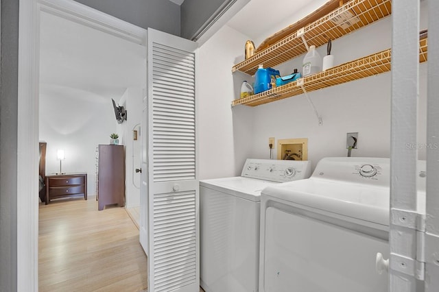 laundry room with light wood-type flooring and washing machine and dryer