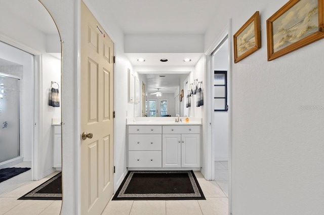 bathroom featuring tile patterned floors, ceiling fan, vanity, and a shower with shower door