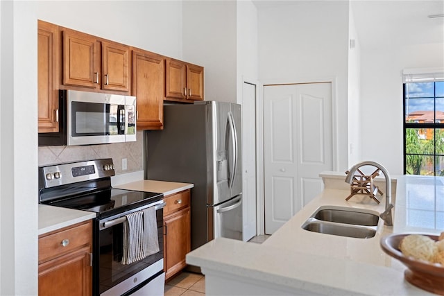 8377 38th Street Cir E Unit 308, Sarasota, FL 34243 - kitchen with stainless steel appliances, a sink, brown cabinets, light countertops, and decorative backsplash