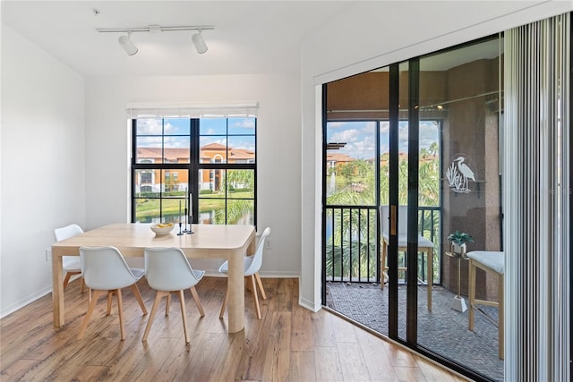 8377 38th Street Cir E Unit 308, Sarasota, FL 34243 - dining room featuring wood-type flooring, rail lighting, and baseboards