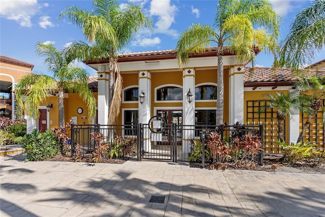8377 38th Street Cir E Unit 308, Sarasota, FL 34243 - view of front of property featuring stucco siding, a tile roof, a gate, and covered porch