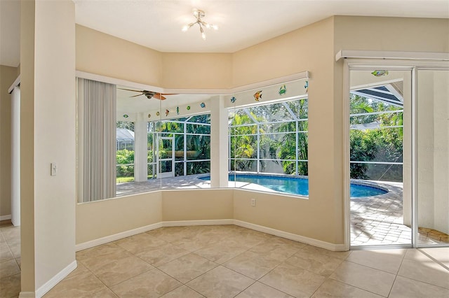 entryway featuring ceiling fan with notable chandelier and light tile patterned floors