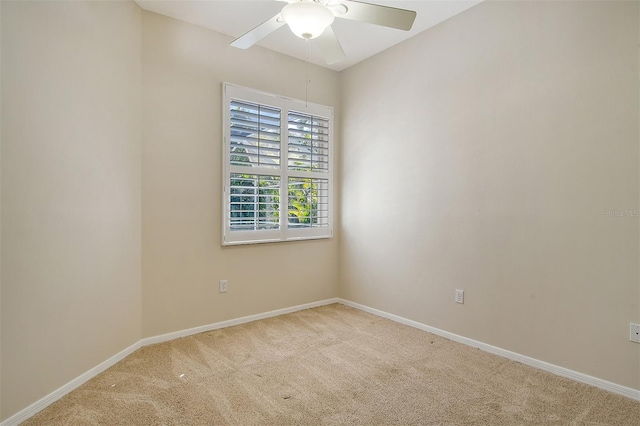 carpeted spare room featuring ceiling fan