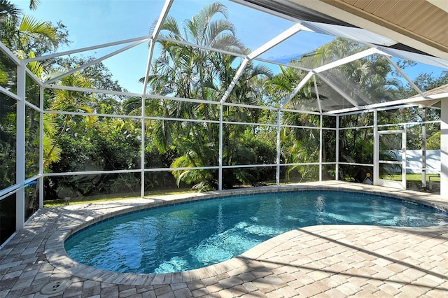 view of swimming pool with glass enclosure and a patio