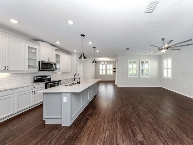 kitchen with dark wood-type flooring, sink, appliances with stainless steel finishes, decorative light fixtures, and white cabinetry