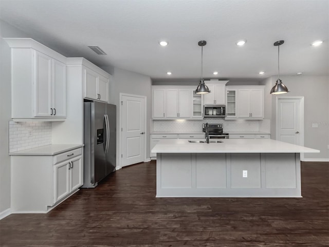 kitchen with dark wood-type flooring, backsplash, decorative light fixtures, white cabinets, and appliances with stainless steel finishes