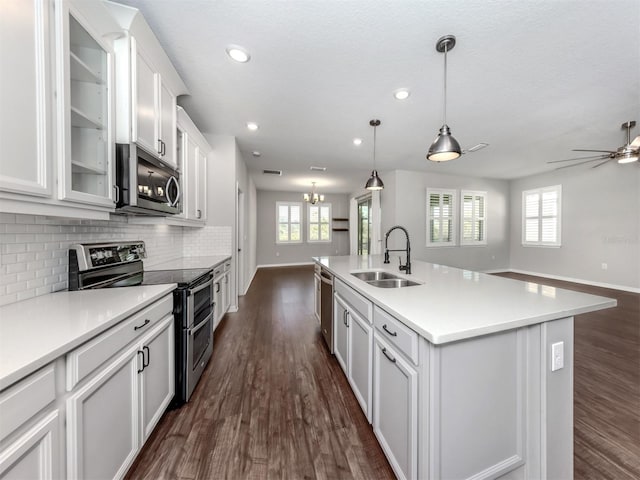 kitchen featuring sink, dark hardwood / wood-style flooring, a center island with sink, white cabinets, and appliances with stainless steel finishes