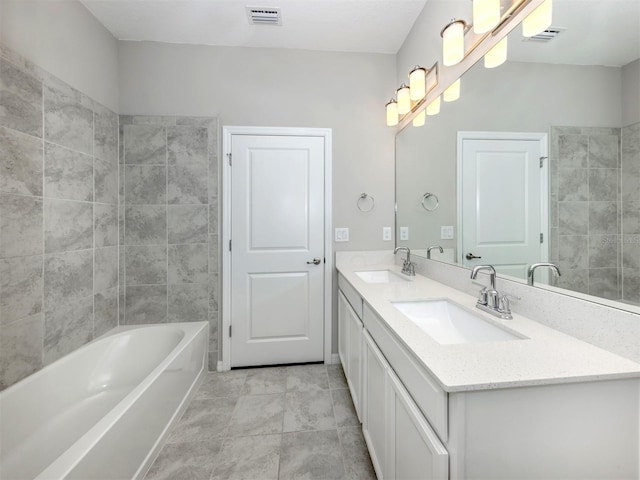 bathroom with tile patterned floors, vanity, and tiled shower / bath combo