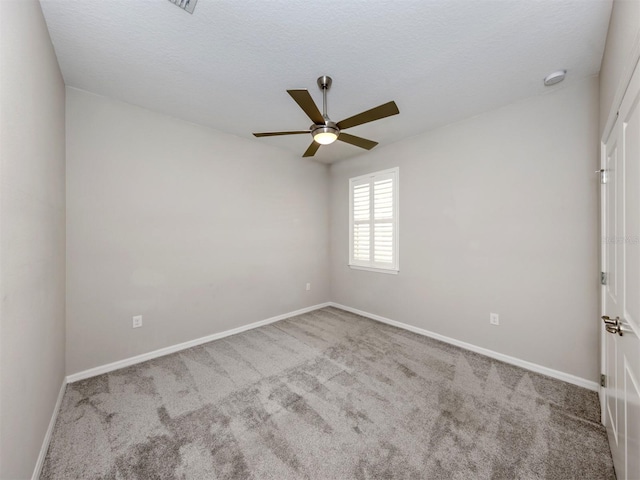 carpeted empty room with ceiling fan and a textured ceiling