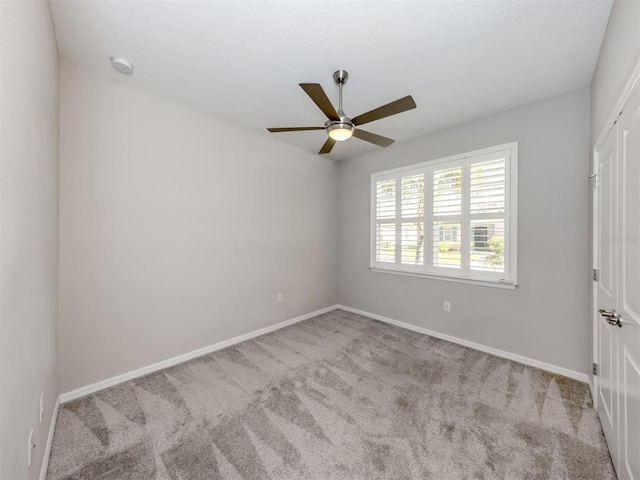 carpeted empty room featuring ceiling fan