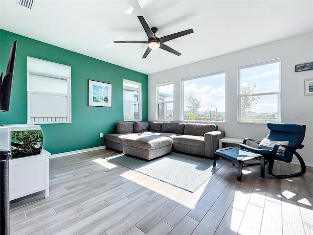 living room with light wood-type flooring and ceiling fan