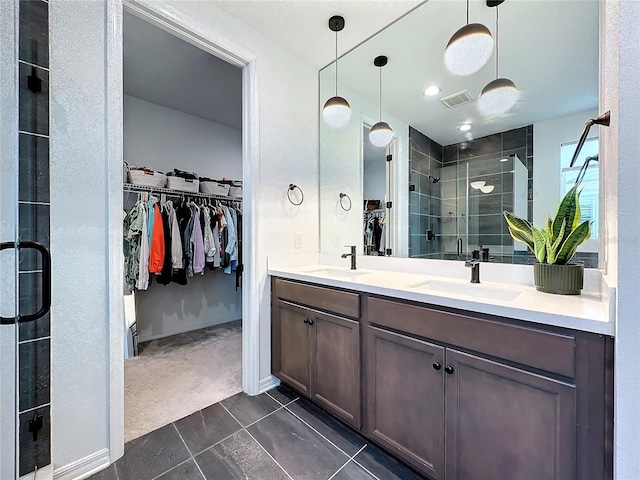 bathroom with a shower with door, tile patterned floors, and vanity