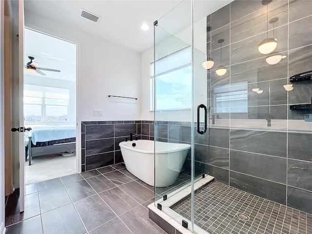 bathroom featuring independent shower and bath, a healthy amount of sunlight, tile walls, and tile patterned flooring