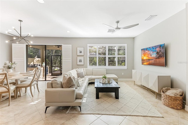 living room with light tile patterned floors and ceiling fan with notable chandelier