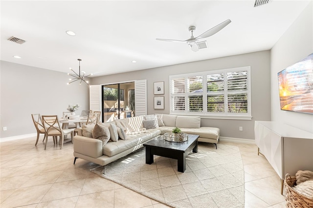 living room featuring ceiling fan with notable chandelier and light tile patterned floors